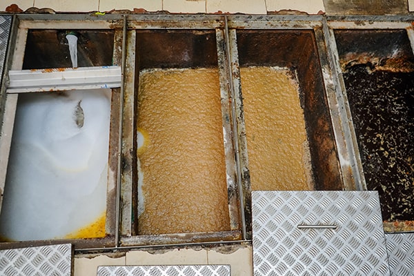 grease trap maintenance involves pumping out accumulated grease and cleaning the trap to remove buildup